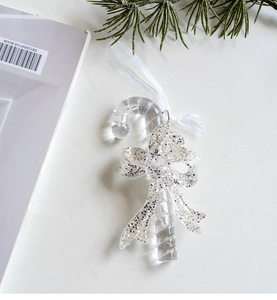 Macro detail of transparent acrylic Christmas candy cane ornament with silver glitter accents