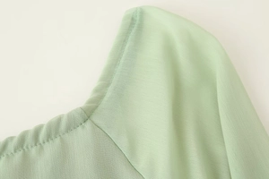 Detailansicht des minzgrünen Rüschenausschnitts und der leichten Textur des Stoffes
