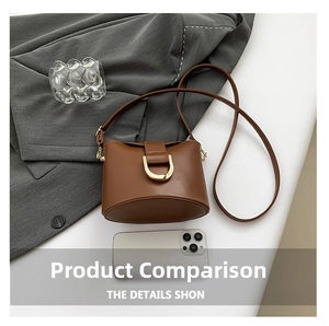 Detail view of a brown leather bucket bag featuring a golden horseshoe clasp and strap