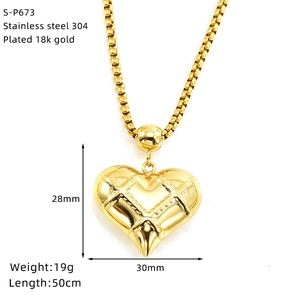 Détail du pendentif cœur en acier inoxydable doré avec motif de texture grillagée fine