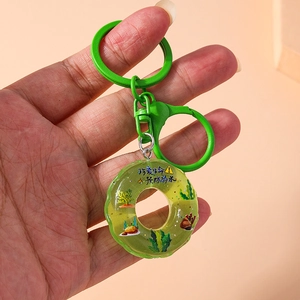 Macro shot of green lifebuoy keychain with resin donut pendant and water safety warning