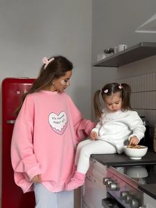 Sweat rose à imprimé cœur pour mère et enfant dans un décor de cuisine chaleureux