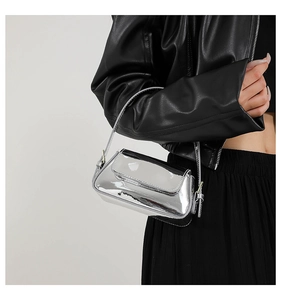 Detail of silver baguette bag showing glossy metallic texture and slim shoulder strap