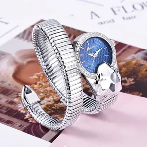 Silver snake-shaped watch with leopard head case and blue quilted dial on magazine