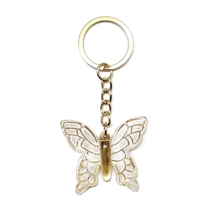 Detail showing transparent acrylic butterfly keychain with gold metallic textures