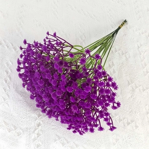 Detailed top view of purple artificial gypsophila bouquet on white lace background