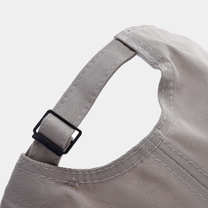 Detail of adjustable cotton baseball cap back strap with black buckle and precise stitching