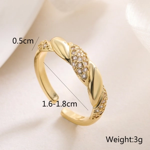 Macro shot of 18K gold plated ring with twisted band, zircon stones and size specifications