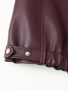 Detail of burgundy PU leather jacket cuff featuring silver snap buttons and ribbed hem