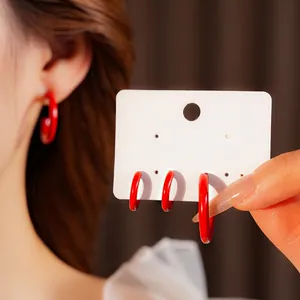 Fashionable C-shaped red enamel hoop earrings with silver pins for a retro luxury look