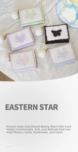 Flat lay of cute bunny trifold wallets in four colors on a lace tablecloth background