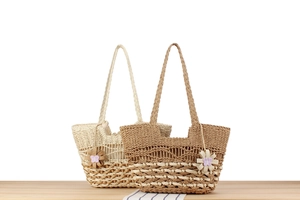 Detail of bohemian hand-woven straw bags with wave patterns and floral charms