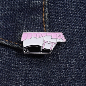 Vue macro d'un badge émaillé de dessin animé avec volants roses sur tissu en denim