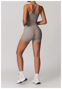 Dettaglio del set yoga tortora con spalline incrociate e pantaloncini a vita alta