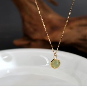 Macro shot of 18K gold plated necklace with a round green natural agate stone pendant
