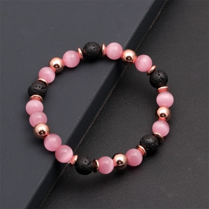 Dettaglio di perline rosa occhio di gatto e pietre laviche nere su bracciale oro rosa