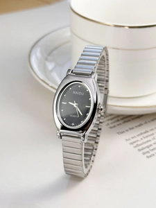 Macro detail of elegant silver metal stretch band and black oval dial quartz watch