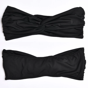 Close-up of black strapless crop top with front twist knot and smooth stretch fabric