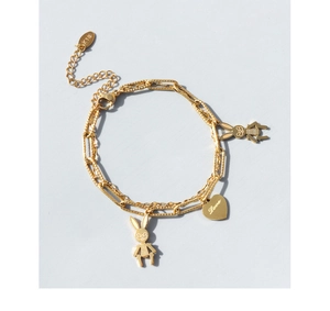 Detail eines 18K vergoldeten Doppelarmbandes mit Hasen- und graviertem Herzanhänger