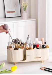 Detail of rotating makeup brush holder with compartments and cream gold drawer