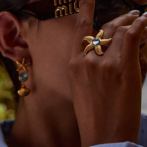 Ocean-themed gold jewelry set with starfish rings and earrings with blue gemstones