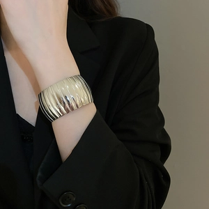 Detail shot of wide silver textured cuff bracelet with vertical ribbing on wrist