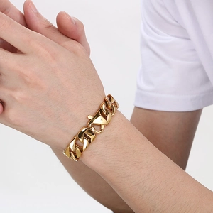 Close-up of a 15mm gold Cuban link chain bracelet worn on a male wrist with polished finish