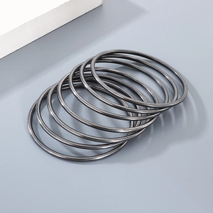 Set of seven 3mm minimalist matte black stainless steel round bangles stacked together