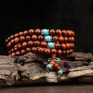 Gros plan de 108 perles de bois de santal avec des intercalaires de turquoise