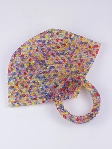 Close-up of colorful faceted acrylic beads on a handmade woven handbag with round handle