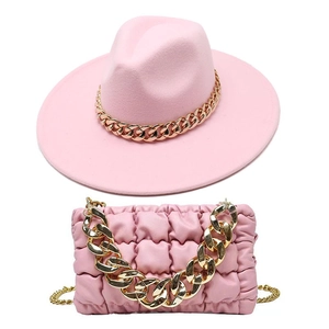 Detailansicht eines rosa Filzhutes mit Goldkette und passender geraffter Handtasche für Damen