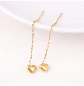 Detail of 18K gold plated heart drop threader earrings on a white porcelain dish