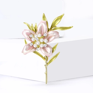 Elegant lily flower brooch with pink enamel petals and pearl detail on white background