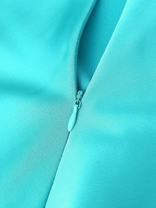 Vue macro de la fermeture éclair invisible sur le tissu en satin bleu sarcelle
