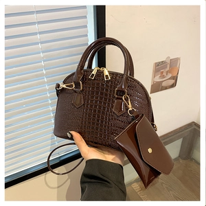 Detail of dark brown croc-pattern shell bag set with gold hardware and mini pouch