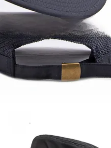 Detail of black mesh trucker hat showing breathable honeycomb fabric and metal buckle