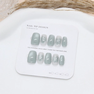 Handmade press-on nails featuring green cat-eye finish and silver bamboo ink designs