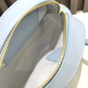 Detailed close-up of blue PU leather dolphin bag with gold metal zipper and white lining