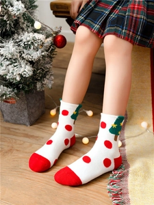 Close-up of knit cotton Christmas sock featuring a green tree and red polka dots
