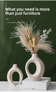 Close-up of matte ceramic vases with sand texture and elegant dried reed arrangement