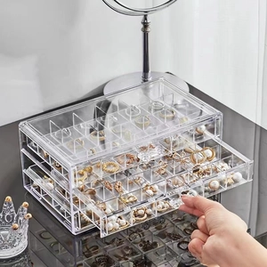 Three-layer acrylic jewelry box detail showing transparent drawers and dividers