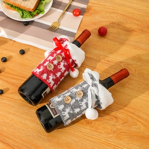Chic knitted Christmas reindeer wine bottle covers in red and grey for festive dining decor