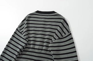 Close-up of the round neckline and knitted texture of the black and white striped sweater