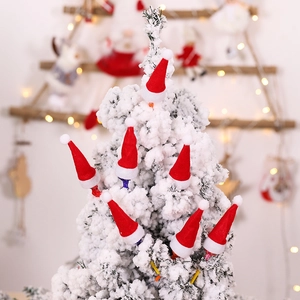 Miniature red felt Santa hats displayed on snowy Christmas trees for festive table decor