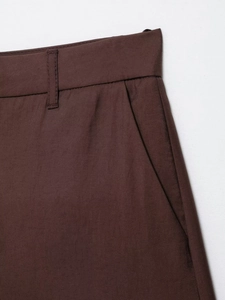 Detail of dark brown blazer shorts set showing waist stitching and side pockets