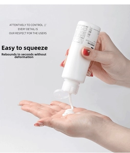 Detail showing hand squeezing a flexible 100ml travel bottle for smooth dispensing