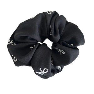 Elegant black scrunchie with white embroidered bow patterns for high ponytail styles