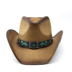 Detail of brown woven cowboy hat featuring green embroidery and silver butterfly buckle
