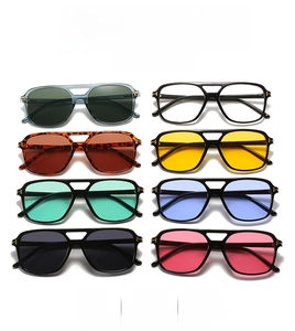 Detail of pilot-style sunglasses with signature metal T-hinge on acetate frame
