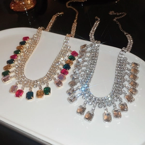 Détail de colliers à franges en cristal doré avec pierres colorées et argenté avec cristaux